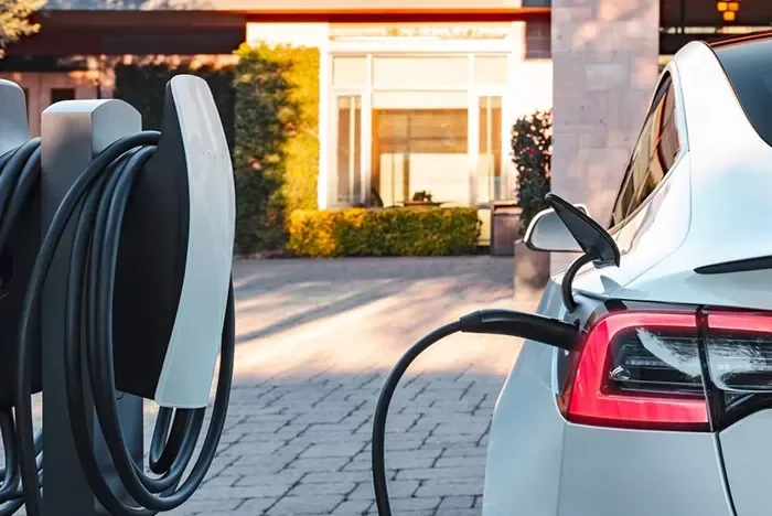 Tesla home charger installation in UK driveway with Tesla Wall Connector and white electric car charging